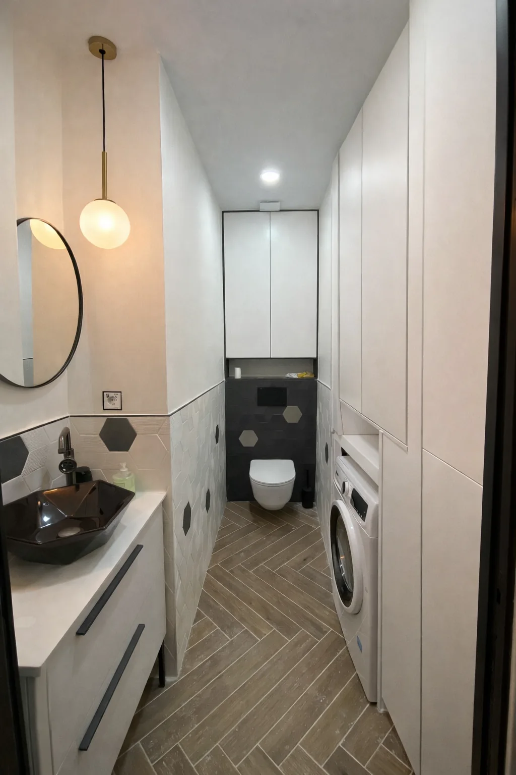 Baño reformado con alicatado de baldosas hexagonales, mueble a medida y lavadora integrada