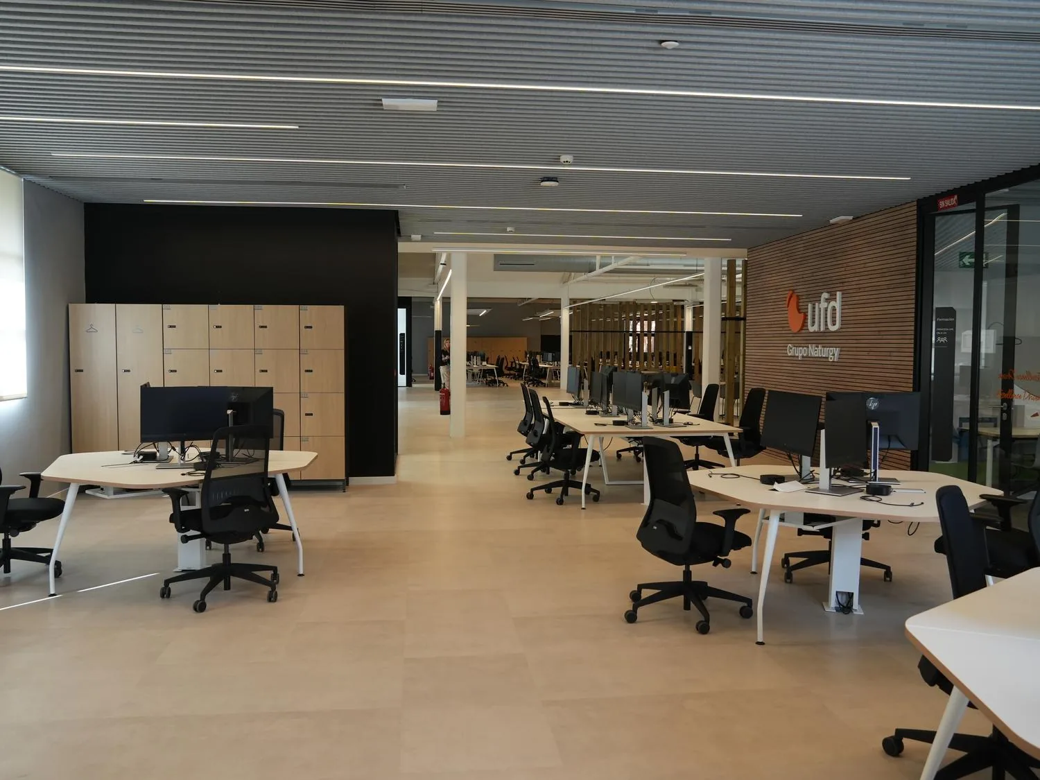Espacio de trabajo abierto de UFD Naturgy, con puestos operativos y taquillas de madera