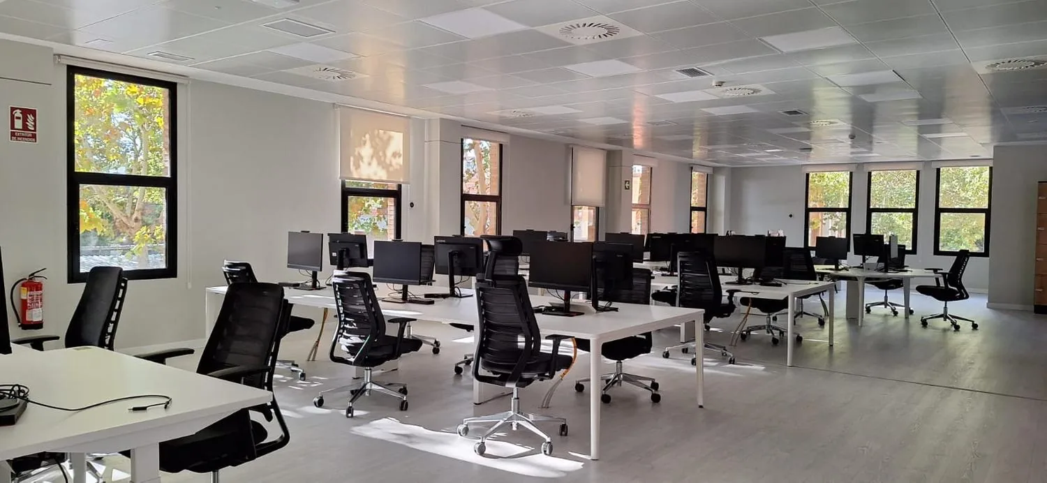 Espacio de trabajo reformado de UFD Naturgy, con techo de madera y puestos abiertos