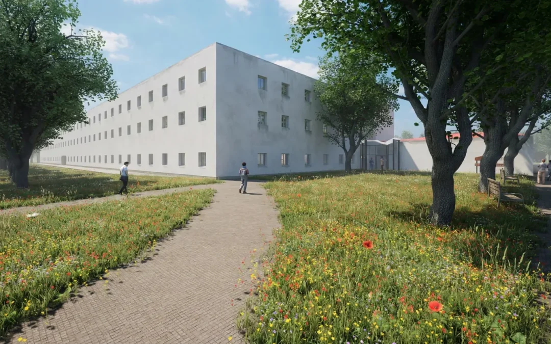 Residencia de la Universidad Laboral de Cáceres rehabilitada, con un camino entre praderas de flores